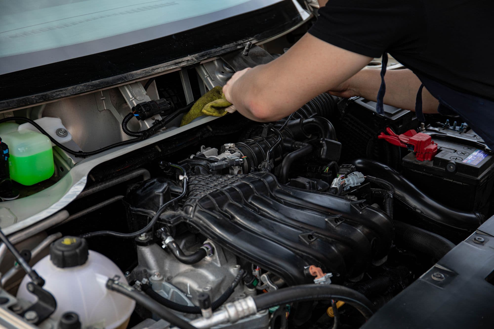 A mechanic working on an engine in a small independent garage
